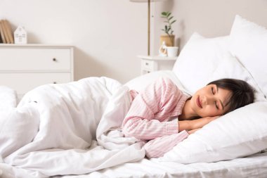 Güzel genç bir kadının yatak odasında yastıkta uyuduğu bir sabah.