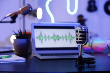 Karanlık stüdyoda, Podcaster 'ın masasındaki profesyonel mikrofon, yakın plan.