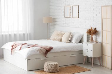 Büyük yatağı, masası ve lambası olan ışık odasının içi.