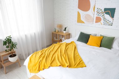 Büyük yataklı ve resimli bir ışık odası.