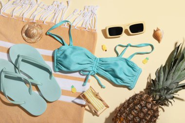 Mayolu yaz kompozisyonu, plaj aksesuarları ve bej arka planda ananas, yakın plan.