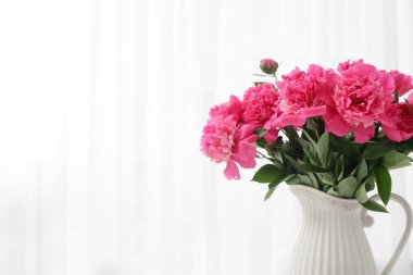 Odanın penceresinin yanında güzel pembe şakayık çiçekli vazo, yakın plan.