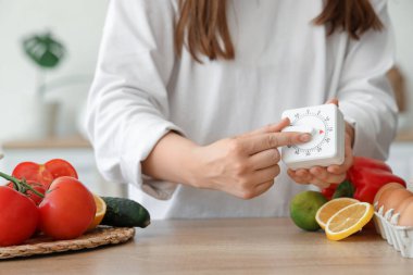 Modern mutfak zamanlayıcısı olan kadın masada, yakın plan.