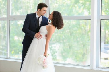 Düğün günlerinde pencerenin kenarında dans eden genç bir çift.