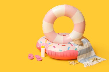 Turuncu arka planda şişme halkalar ve plaj aksesuarları, yakın plan.