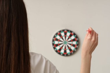 Genç kadın arka planda dart oynuyor