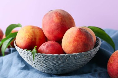 Masada leylak arkaplanına karşı bir kase taze şeftali