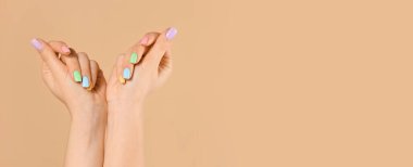 Renkli arka planda güzel manikürlü genç bir kadının elleri