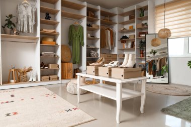 Açık butikte şık kıyafetler, ayakkabılar ve aksesuarlar.