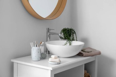 Lavabo lavabosu ve banyo aksesuarlarıyla dolu bir masa.