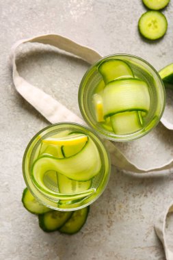 Gri masada salatalık dilimleri ile doldurulmuş su bardakları