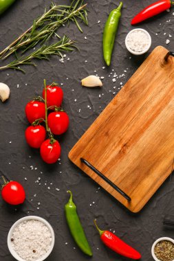 Taze sebzeler, baharatlar ve arka planda ahşap mutfak tahtasıyla kompozisyon.