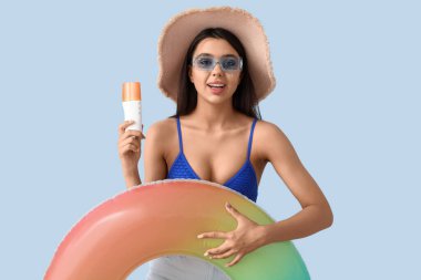 Güneş kremi sürmüş ve yüzme yüzüklü güzel bir genç kadın.