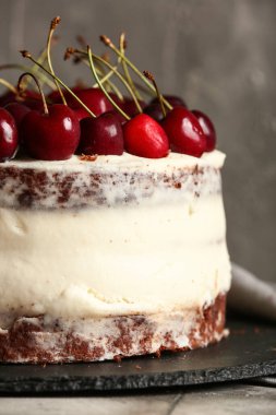 Gri arka planda lezzetli vişneli kek olan tahta