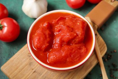 Ahşap tahta tahta tahta, arka planda konserve domates, yakın plan.