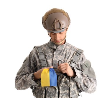 Beyaz arka planda Ukrayna bayrağı taşıyan genç erkek asker
