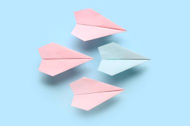 Mavi arkaplanda renkli origami kağıt uçaklar