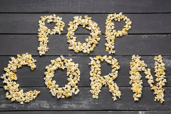 Текст POP CORN на темном деревянном фоне