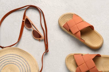 Hafif arka planda plaj aksesuarları olan şık bayan terlikleri.