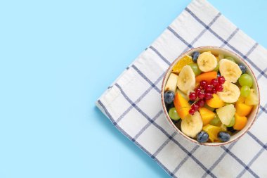 Mavi arka planda taze meyve salatası.
