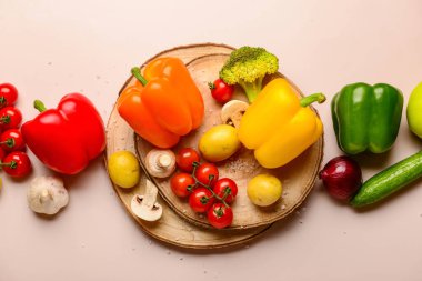 Bej arka planda farklı taze sebzeleri olan tahta tahtalar.