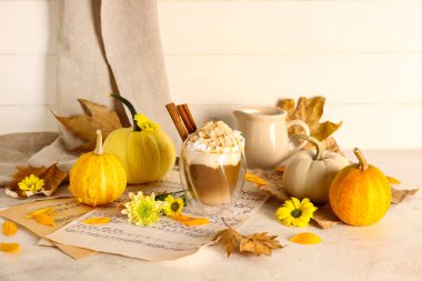 Beyaz masada tarçınlı ve bademli balkabaklı latte.