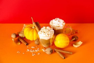 Renkli arkaplanda tarçınlı ve bademli balkabaklı latte.