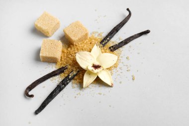 Aromatik vanilya şekeri, çiçek ve gri arkaplanda çubuklar