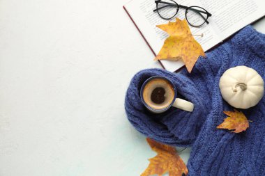 Bir fincan aromatik kahve, sıcak süveter ve açık arkaplan üzerine kitap kompozisyonu