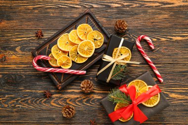 Hediye kutuları ve tahta arka planda şeker kamışlı kurutulmuş portakal dilimleri.