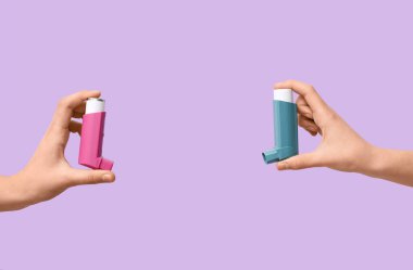 Leylak arka planında astım spreyleri olan çocuk elleri.