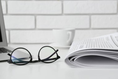 Beyaz masada gazeteli bardaklar