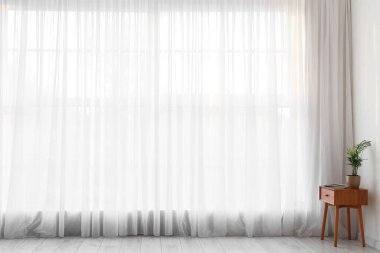 Işık perdesi ve masası olan bir oda.