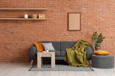 Oturma odasının içinde kanepe, puf ve masa var.