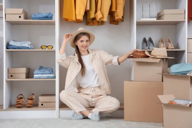 Güzel, genç, mutlu bir kadın. Bir sürü dolabı ve şık kıyafetleri var. Soyunma odasında oturuyor.