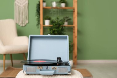 Odadaki sehpanın üzerinde diski olan bir plak çalar.