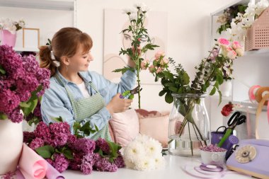 Çiçek buketi için çiçek kesen kadın çiçekçi.