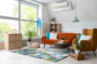 Kanepesi, koltuğu ve sörf tahtası olan modern bir oturma odası.