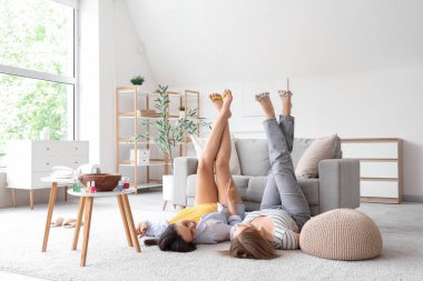 Ayak parmaklarını ayıran genç kadınlar oturma odasında pedikür yapıyorlar.