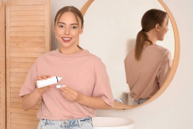 Genç bir kadın konteynıra kontak lensli solüsyon dolduruyor.