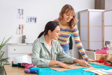 Atölyedeki masada çalışan kadın terziler