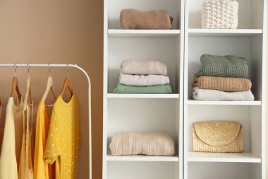 Renkli duvarın yanında şık giysileri rafa kaldırıyorum.