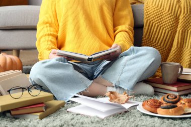 Evdeki halıda kitap okuyan kadın, yakın plan.