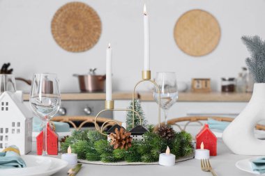 Noel kutlaması için güzel bir masa. Yemek odasında çelenk ve mumlarla.