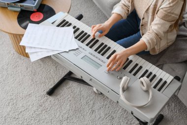 Evde sentezleyici çalan kadın