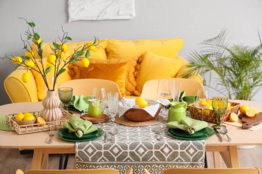 Taze narenciye ve güzel limon dallarıyla süslenmiş şık yeşil masa.