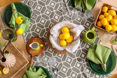 Yemek odasında bir sürü taze limonla dekore edilmiş şık yeşil masa.