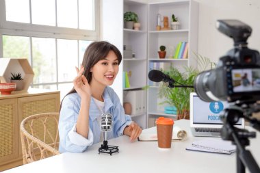 Genç bir kadın stüdyoda podcast yapıyor.