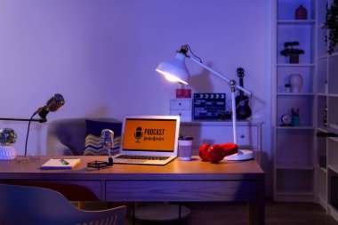 Podcaster 'ın iş yeri. Karanlık stüdyoda dizüstü bilgisayarlar, mikrofonlar ve parlayan lambalar.