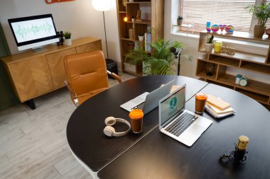 Podcaster 'ın atölyesinin içinde çalışma yeri ve raf üniteleri var.